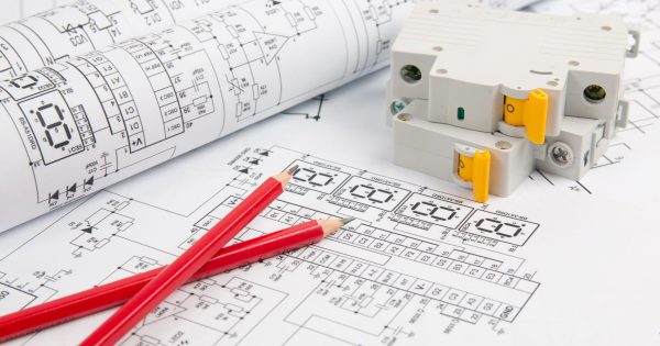 circuit breaker and pencils on paper electrical engineering drawings